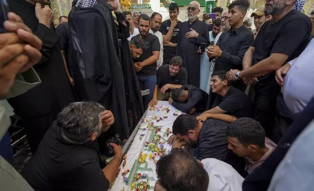 Relatives mourn over the coffin of Zulfikar Dergham Musa Al-Jabouri, in Najaf, Iraq, Thursday, Sept. 26, 2024 who died in Israeli airstrikes on Sept. 23 fighting alongside Hezbollah in Tyre, south Lebanon. (AP Photo/Anmar Khalil)