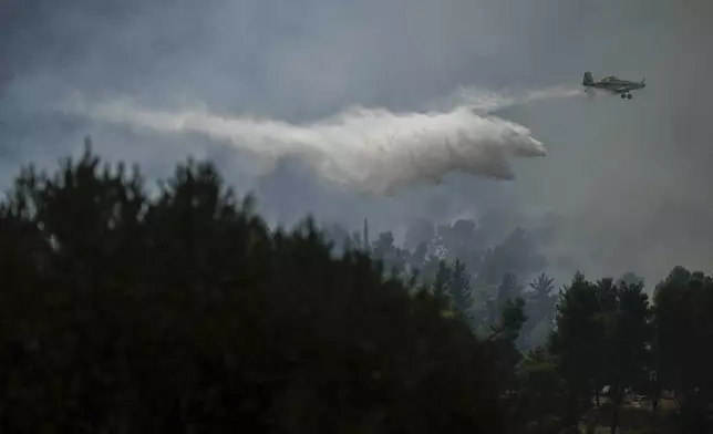 An Israeli firefighters plane uses a fire retardant to extinguish a fire after a rocket fired from Lebanon hit an open area near the city of Safed, northern Israel, on Wednesday, Sept. 25, 2024. (AP Photo/Leo Correa)