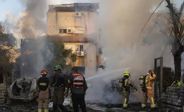 Israeli security and rescue forces work at the site hit by a rocket fired from Lebanon, in Kiryat Bialik, northern Israel, on Sunday, Sept. 22, 2024. (AP Photo/Gil Nechushtan)