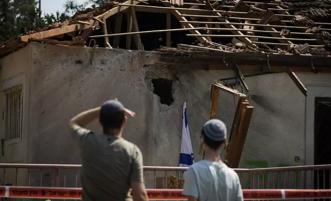 People look at a damaged house that was hit by a rocket fired from Lebanon, near Safed, northern Israel, on Wednesday, Sept. 25, 2024. (AP Photo//Leo Correa)