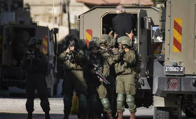 Israeli soldiers arrest a blindfolded Palestinian during an army raid in Tubas, West Bank, on Wednesday, Sept. 11, 2024. (AP Photo/Majdi Mohammed)