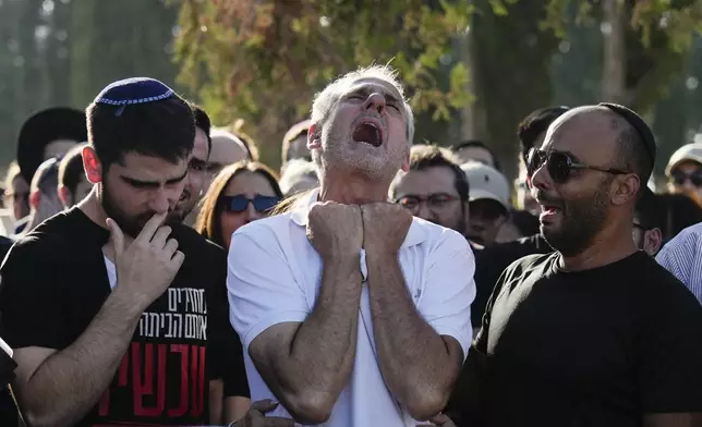 Yigal Sarusi, center, mourns during the funeral of his son, slain hostage Almog Sarusi, who was killed in Hamas captivity in the Gaza Strip, at a cemetery in Ra'anana, Israel, Sunday, Sept. 1, 2024. (AP Photo/Ariel Schalit)