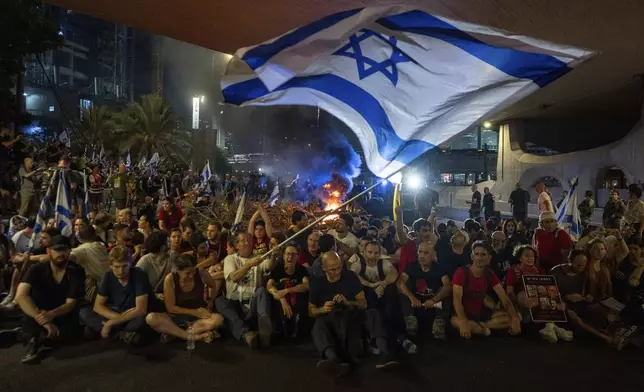 People block a road as they protest, calling for a deal for the immediate release of hostages held in the Gaza Strip by Hamas, in Tel Aviv, Israel, Sunday, Sept. 1, 2024. (AP Photo/Ohad Zwigenberg)