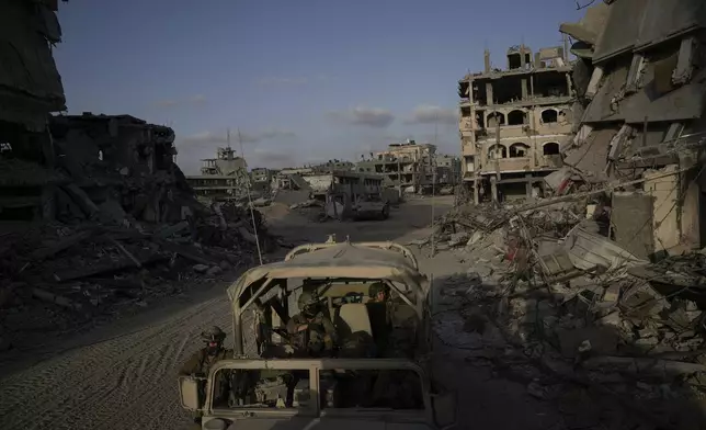 Israeli soldiers move next to destroyed buildings following Israeli strikes during a ground operation in the Gaza Strip on Friday, Sept. 13, 2024. (AP Photo/Leo Correa)