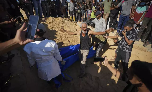 People bury the bodies of Palestinians taken by the Israeli military during operations in Gaza and returned this week, in Khan Younis, Gaza Strip, Thursday, Sept. 26, 2024. (AP Photo/Abdel Kareem Hana)