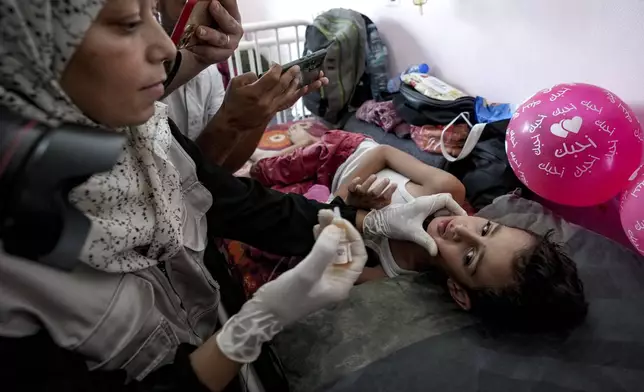 A health worker administers a polio vaccine to a child at a hospital in Khan Younis, Saturday, Aug. 31, 2024. (AP Photo/Abdel Kareem Hana)