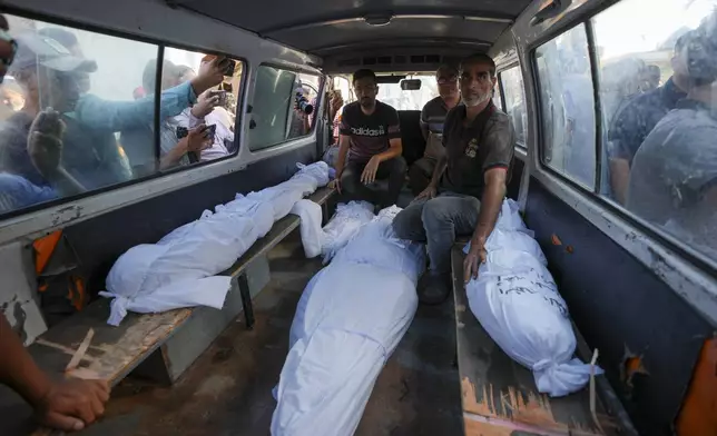 Mourners transport the bodies of their relatives killed in the Israeli bombardment of the Gaza Strip during their funeral in Deir al-Balah, Gaza, Monday, Sept. 23, 2024. (AP Photo/Abdel Kareem Hana)