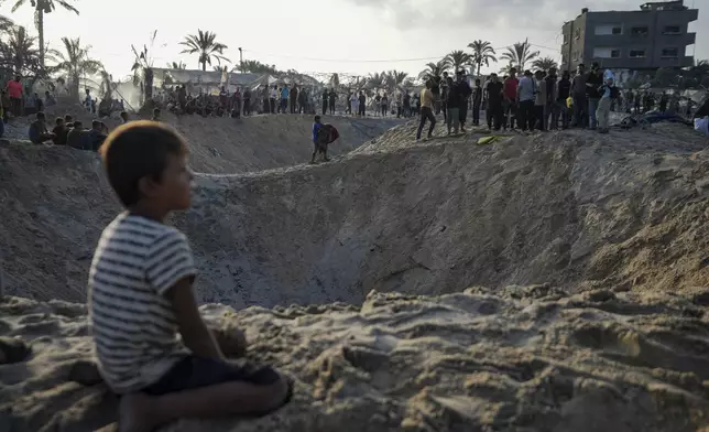 Palestinians look at the destruction after an Israeli airstrike on a crowded tent camp housing Palestinians displaced by the war in Muwasi, Gaza Strip, Tuesday, Sept. 10, 2024. An Israeli strike killed at least 40 people and wounded 60 others early Tuesday, Palestinian officials said. Israel said it targeted "significant" Hamas militants, allegations denied by the militant group. (AP Photo/Abdel Kareem Hana)