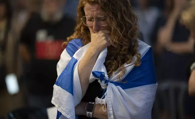 A woman closes her eyes during a vigil in memory of slain hostage Hersh Goldberg-Polin in Jerusalem, Israel, Sunday, Sept. 1, 2024. (AP Photo/Leo Correa)