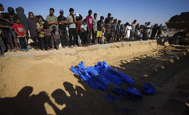 People bury the bodies of Palestinians taken by the Israeli military during operations in Gaza and returned this week, in Khan Younis, Gaza Strip, Thursday, Sept. 26, 2024. (AP Photo/Abdel Kareem Hana)