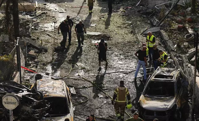 Israeli security forces examine the site hit by a rocket fired from Lebanon, in Kiryat Bialik, northern Israel, on Sunday, Sept. 22, 2024. (AP Photo//Ariel Schalit)