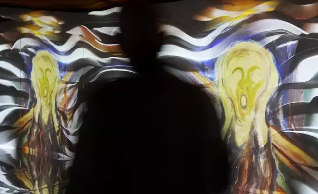 Visitors watch an immersive video during a press preview of the Edvard Munch exhibition at Palazzo Reale in Milan, Italy, Friday, Sept. 13, 2024. The exhibition will run from Sept. 14, 2024 to Jan. 26, 2025. (AP Photo/Luca Bruno)