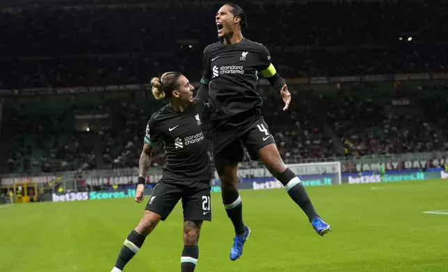 Liverpool's Virgil van Dijk, left, celebrates after scoring his side's second goal during the Champions League opening phase soccer match between AC Milan and Liverpool at the San Siro stadium in Milan, Italy, Tuesday, Sept. 17, 2024. (AP Photo/Antonio Calanni)