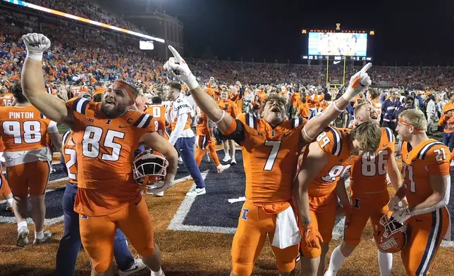 Illinois players celebrate the team's 23-17 upset win over Kansas after an NCAA college football game Saturday, Sept. 7, 2024, in Champaign, Ill. (AP Photo/Charles Rex Arbogast)