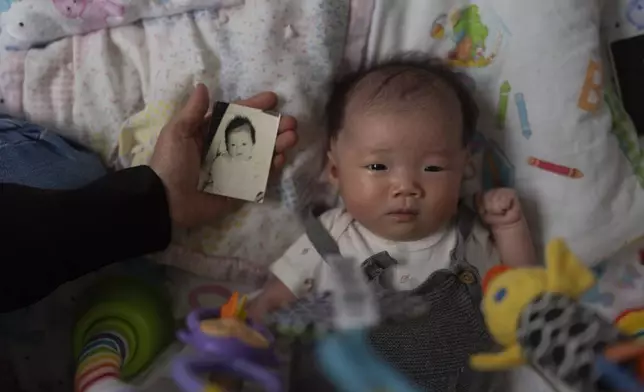 Michaela Dietz, an adoptee from South Korea, holds a baby photo of Robyn Joy Park, who was also adopted from South Korea as an infant and whose identity was switched, next to Park's newborn daughter, Rae, while visiting Park at her home in Pasadena, Calif., Friday, April 19, 2024. Park hasn't found her real parents. She thinks often of the girl whose identity she was given, and wonders: what happened to her? (AP Photo/Jae C. Hong)