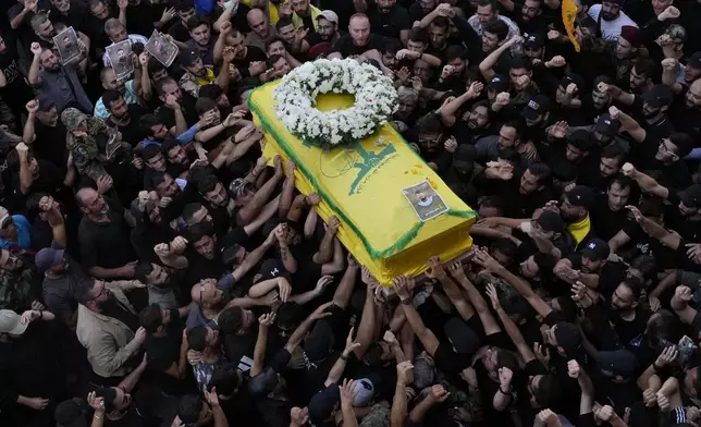 Hezbollah members carry the coffin of their comrade who was killed when a handheld device exploded, during a funeral procession in the southern suburbs of Beirut, Thursday, Sept. 19, 2024. (AP Photo/Hussein Malla)