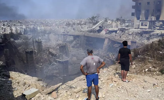 People check a damaged building at the site of an Israeli airstrike in Choueifat, south east of Beirut, Saturday, Sept. 28, 2024. (AP Photo/Hussein Malla)