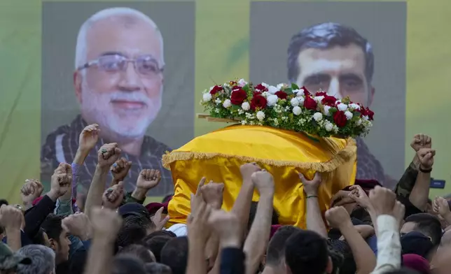 Hezbollah members carry the coffins of Hezbollah commanders Ibrahim Kobeisi, seen in the picture left, and Hussein Ezzedine, right, during their funeral procession in Beirut's southern suburb, Wednesday, Sept. 25, 2024. (AP Photo/Hassan Ammar)