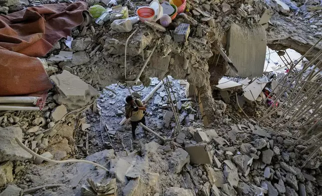 A photographer documents damage in a building that was hit by an Israeli airstrike in Beirut's southern suburb, Lebanon, Monday, Sept. 30, 2024. (AP Photo/Hassan Ammar)