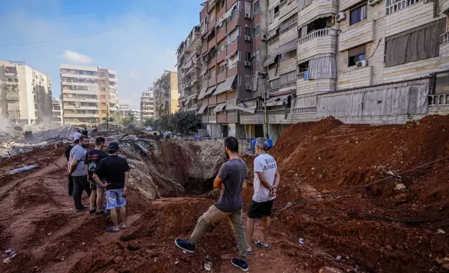 People gather at the site of the assassination of Hezbollah leader Hassan Nasrallah in Beirut's southern suburbs, Sunday, Sept. 29, 2024. (AP Photo/Hassan Ammar)