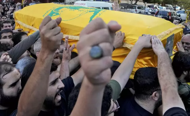 Mourners chant slogans as they carry the coffin of Hezbollah drone commander, Mohammed Hussein Surour, during his funeral procession in Beirut's southern suburbs, Friday, Sept. 27, 2024. (AP Photo/Bilal Hussein)