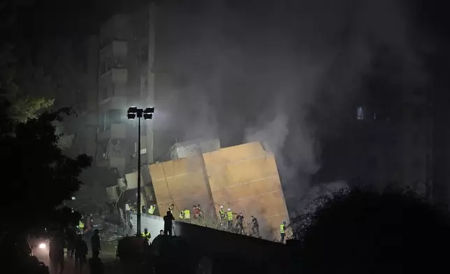 Rescuers arrive at the site of an Israeli airstrike in Beirut's southern suburbs, Friday, Sept. 27, 2024. (AP Photo/Hassan Ammar)