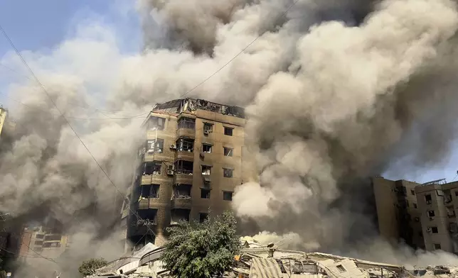 Smoke rises as a building collapses in Beirut's southern suburbs, Saturday, Sept. 28, 2024. (AP Photo/Hussein Malla)