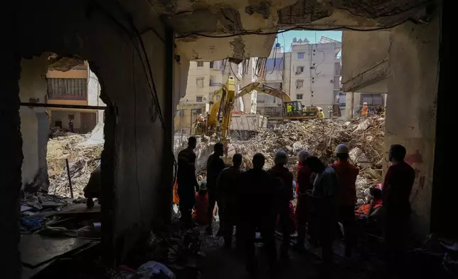 Emergency workers use excavators to clear the rubble at the site of Friday's Israeli strike in Beirut's southern suburbs, Lebanon, Monday, Sept. 23, 2024. (AP Photo/Hassan Ammar)