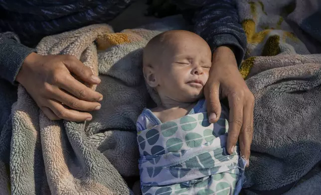 A woman cares for her newborn girl, Fatima, in Beirut's Martyrs' square after fleeing the Israeli airstrikes in the southern suburbs of Dahiyeh, Sunday, Sept. 29, 2024. (AP Photo/Bilal Hussein)