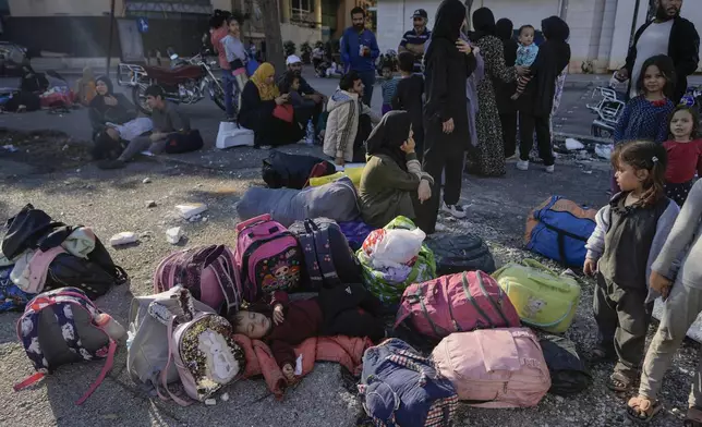 Families gather in Martyrs' square after fleeing the Israeli airstrikes in Beirut's southern suburbs, Saturday, Sept. 28, 2024. (AP Photo/Bilal Hussein)