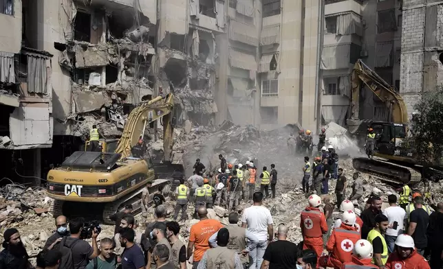 Emergency workers use excavators to clear the rubble at the site of Friday's Israeli strike in Beirut's southern suburbs, Saturday, Sept. 21, 2024. (AP Photo/Bilal Hussein)