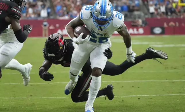 Detroit Lions running back Jahmyr Gibbs (26) scores a touchdown on a run after receiving a lateral from wide receiver Amon-Ra St. Brown during the first half of an NFL football game against the Arizona Cardinals Sunday, Sept. 22, 2024, in Glendale, Ariz. (AP Photo/Ross D. Franklin)