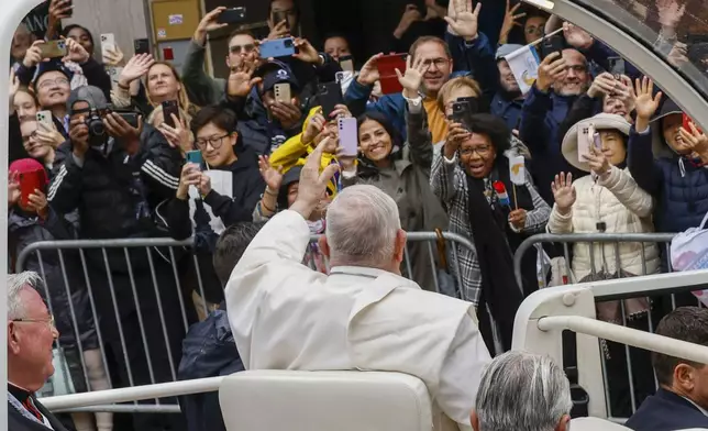 Pope Francis waves at a cheering crowd as he leaves with Archbishop of Luxembourg, Cardinal Jean-Claude Hollerich, left, in a popemobile the Cercle-Cite convention center in Luxembourg after a meeting with the national authorities and the civil society on the first day of Francis's four-day visit to Luxembourg and Belgium, Thursday, Sept. 26, 2024. (AP Photo/Omar Havana)