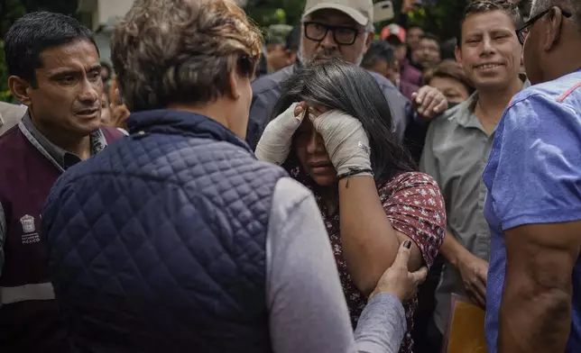 Estrella Bejarano, center, the mother of two children who died after a rain-induced landslide, speaks with Mexico State Governor Delfina Gomez in Naucalpan, Mexico, Tuesday, Sept. 17, 2024. (AP Photo/Felix Marquez)