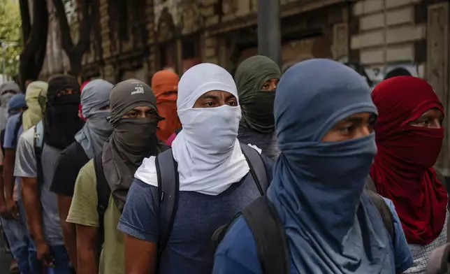 Hooded students demonstrate ahead of the 10th anniversary of the disappearance of 43 Ayotzinapa students in Guerrero state, outside the Interior Ministry in Mexico City, Monday, Sept. 23, 2024. (AP Photo/Felix Marquez)