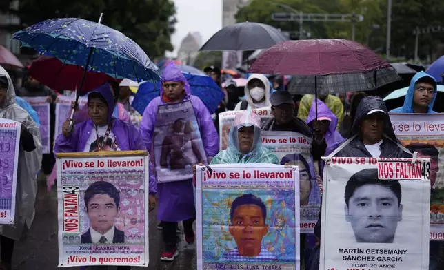 Families and friends they take part in a demonstration marking the 10-year anniversary of the disappearance of 43 students from an Ayotzinapa rural teacher's college, in Mexico City, Thursday, Sept. 26, 2024. (AP Photo/Eduardo Verdugo)