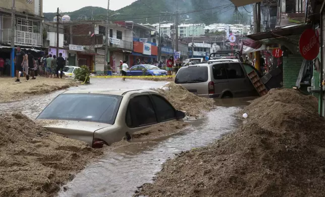 Vehicles are partially submerged on a flooded street in the aftermath of Hurricane John in Acapulco, Mexico, Saturday, Sept. 28, 2024. (AP Photo/Alejandrino Gonzalez)