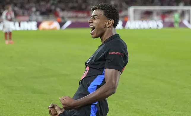 Barcelona's Lamine Yamal celebrates after scoring his side's opening goal during the Champions League opening phase soccer match between Monaco and Barcelona at the Louis II stadium, in Monaco, Monaco, Thursday, Sept. 19, 2024. (AP Photo/Laurent Cipriani)