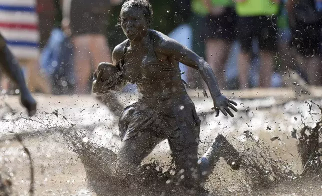 Mahala Smith, of Sabattus, Maine, scrambles for yardage during a women's football game at the Mud Bowl in North Conway, N.H., Saturday, Sept. 7, 2024. (AP Photo/Robert F. Bukaty)