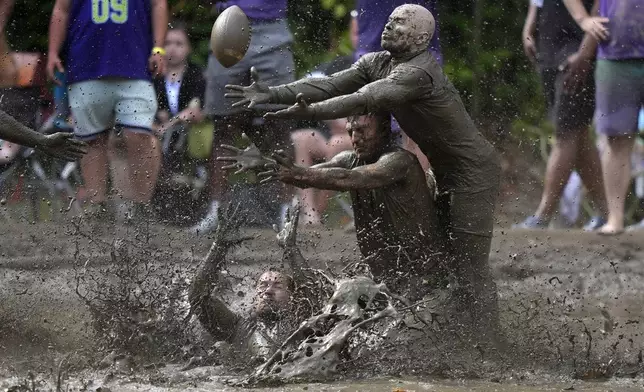 Eric Germelli, bottom, and Kevin Terban, of the Mudsharks, defend against Josh Phillips, of the Muddas, on a pass in a football game at the Mud Bowl in North Conway, N.H., Sunday, Sept. 8, 2024. (AP Photo/Robert F. Bukaty)