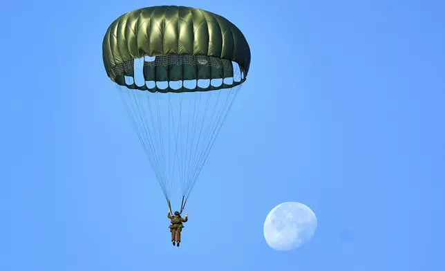 Parachutists jump over Ginkel Heath Netherlands, Saturday, Sept. 21, 2024, to mark the 80th anniversary of an audacious by unsuccessful World War II mission codenamed Market Garden to take key bridges in the Netherlands. (AP Photo/Phil Nijhuis)