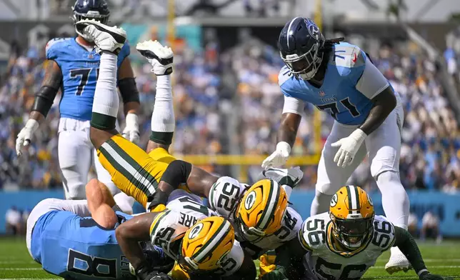 Tennessee Titans' Will Levis is sacked by Green Bay Packers' Kingsley Enagbare (55), Rashan Gary (52) and Edgerrin Cooper (56) during the second half of an NFL football game Sunday, Sept. 22, 2024, in Nashville, Tenn. (AP Photo/John Amis)