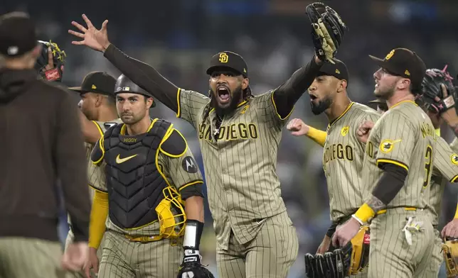 San Diego Padres' Fernando Tatis Jr., center, celebrates with teammates after the Padres clinched a playoff spot with a triple play to end their baseball game against the Los Angeles Dodgers, Tuesday, Sept. 24, 2024, in Los Angeles. (AP Photo/Mark J. Terrill)