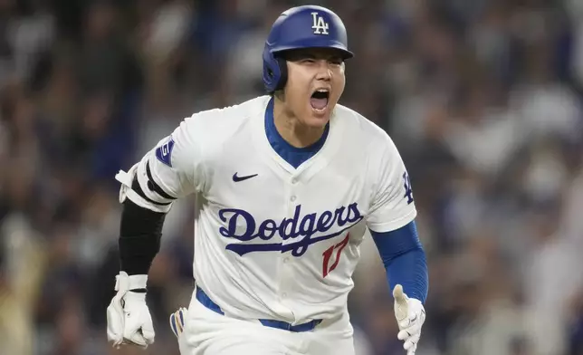 Los Angeles Dodgers designated hitter Shohei Ohtani reacts as he singles during the sixth inning of a baseball game against the San Diego Padres in Los Angeles, Wednesday, Sept. 25, 2024. Will Smith scored. (AP Photo/Ashley Landis)