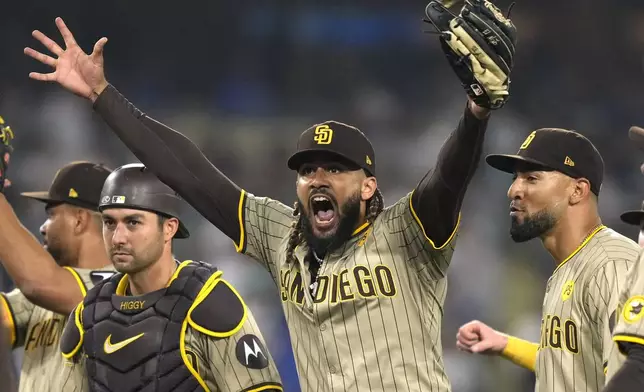 San Diego Padres' Fernando Tatis Jr., center, celebrates with teammates after the Padres clinched a playoff spot with a triple play to end their baseball game against the Los Angeles Dodgers, Tuesday, Sept. 24, 2024, in Los Angeles. (AP Photo/Mark J. Terrill)