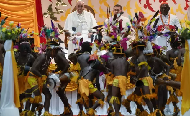 Pope Francis, left, with Cardinal Archbishop of Port Moresby John Ribat, right, attend a traditional dance performed by the pupil of the Caritas Technical Secondary School in Port Moresby, Saturday, Sept. 7, 2024. As a second leg of his 11-day trip to Asia and Oceania Pope Francis's visit to Papua New Guinea will take him to a remote part of the South Pacific island nation where Christianity is a recent addition to traditional spiritual beliefs developed over millennia. (AP Photo/Gregorio Borgia)