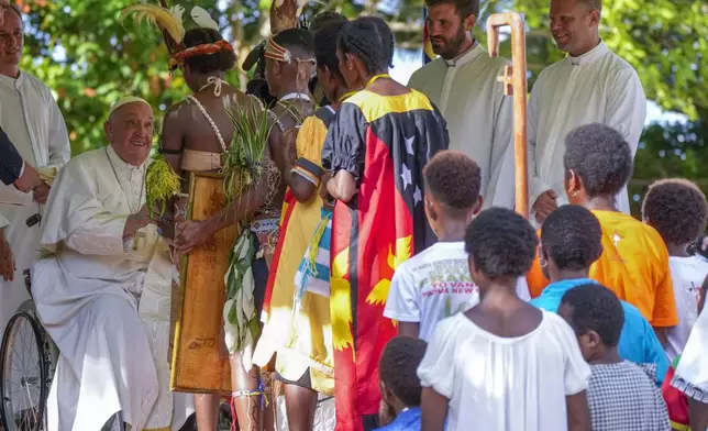 Pope Francis, left, meets with indigenous people at the Holy Trinity Humanistic School in Baro, near Vanimo, Papua New Guinea, Sunday, Sept. 8, 2024. Pope Francis celebrated the Catholic Church of the peripheries on Sunday as he traveled to the remote jungles of Papua New Guinea, bringing with him a ton of medicine and toys and a message of love overcoming violence for the people who live there.(AP Photo/Gregorio Borgia)