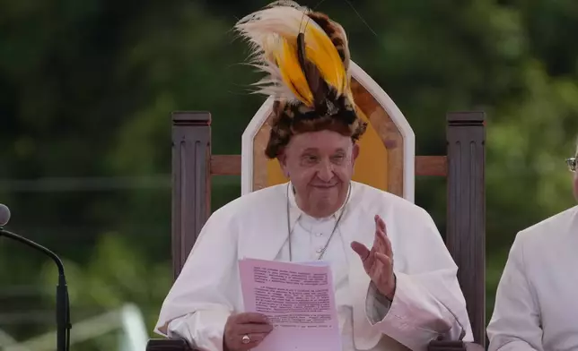 Pope Francis wears a traditional hat during a meeting with faithful in Vanimo, Papua New Guinea, Sunday, Sept. 8, 2024. . (AP Photo/Gregorio Borgia)