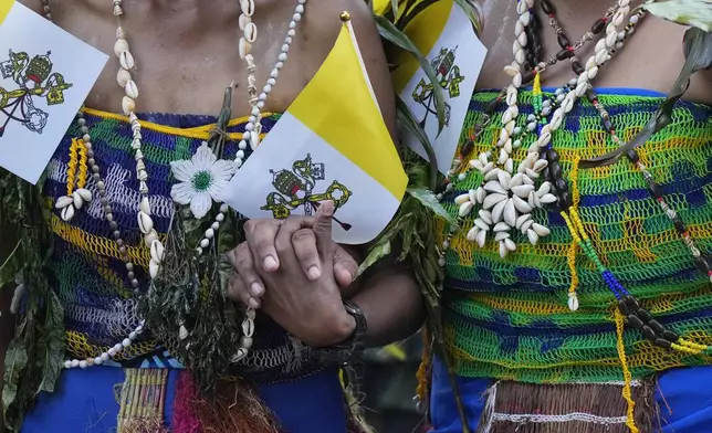 Two dancers hold hands as they wait for the arrival of Pope Francis at Caritas Technical Secondary School in Port Moresby, Papua New Guinea, Saturday, Sept. 7, 2024. (AP Photo/Mark Baker)