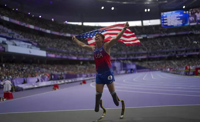 Hunter Woodhall from the U.S. celebrates after winning the men's 400 m. T62 final at the 2024 Paralympics, Friday, Sept. 6, 2024, in Paris, France. (AP Photo/Thibault Camus)